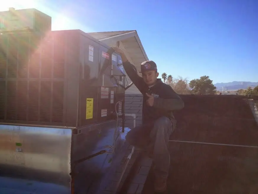 HVAC technician performing AC Tune-Up on a rooftop unit in Hartsville